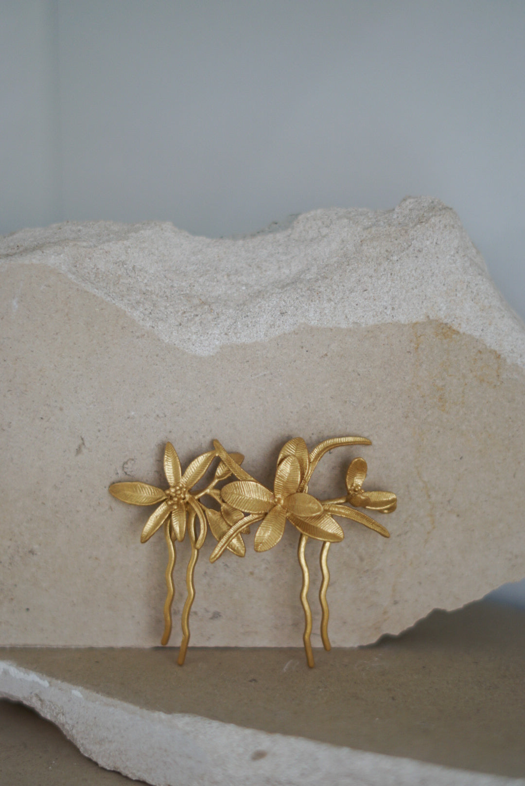 Gancho ou Toucado Dourado com folhas e flores na mesma cor.