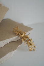 Acessório para Cabelo na cor dourada e com flores no mesmo tom.